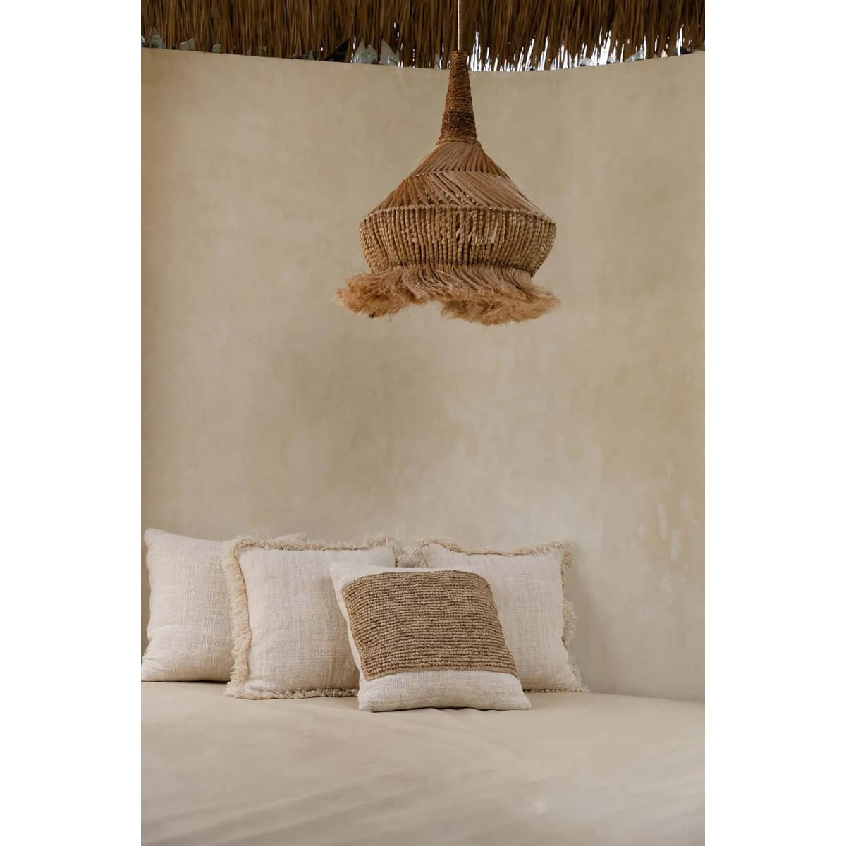 Alt Tag: Sfeervolle kamer met raffia lamp en kussen met natuurlijk ontwerp, ideaal voor een stijlvolle en rustieke uitstraling.