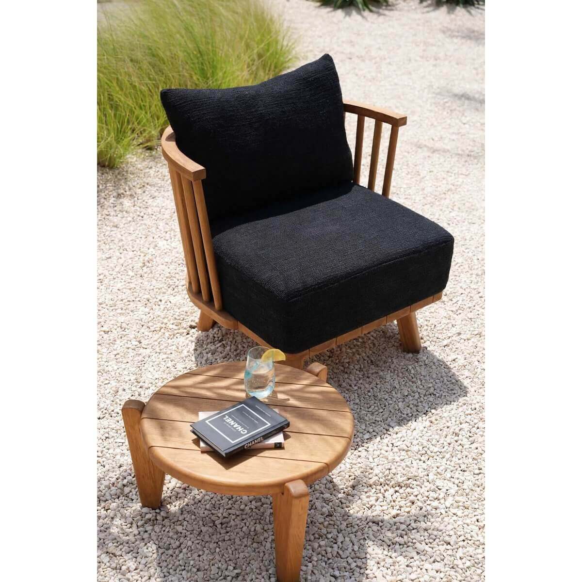 Houten Seseh-salontafel met boek en glas buiten op grindpad bij stijlvolle stoel, modern tuinontwerp.