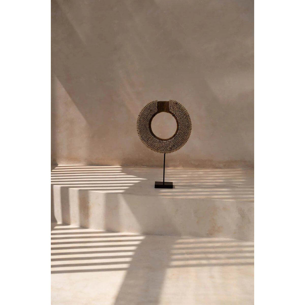 Decoratief Shell Réunion ornament op een standaard in een zonovergoten ruimte, perfect voor stijlvolle woondecoratie.