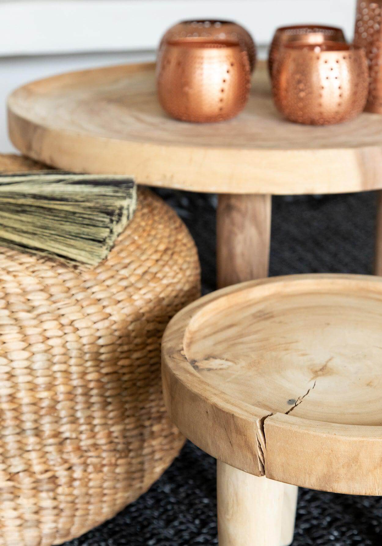 Bijzettafel De Suar in natuurlijke boho-stijl met houten en rotan details, ideaal voor woonkamer of terras, gecombineerd met koperen kaarsenhouders.