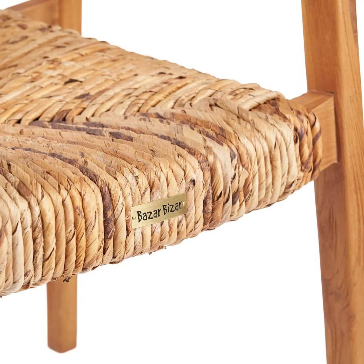 Een close-up van de zitting van de De Suma eetkamerstoel, met geweven rieten ontwerp en een houten frame.