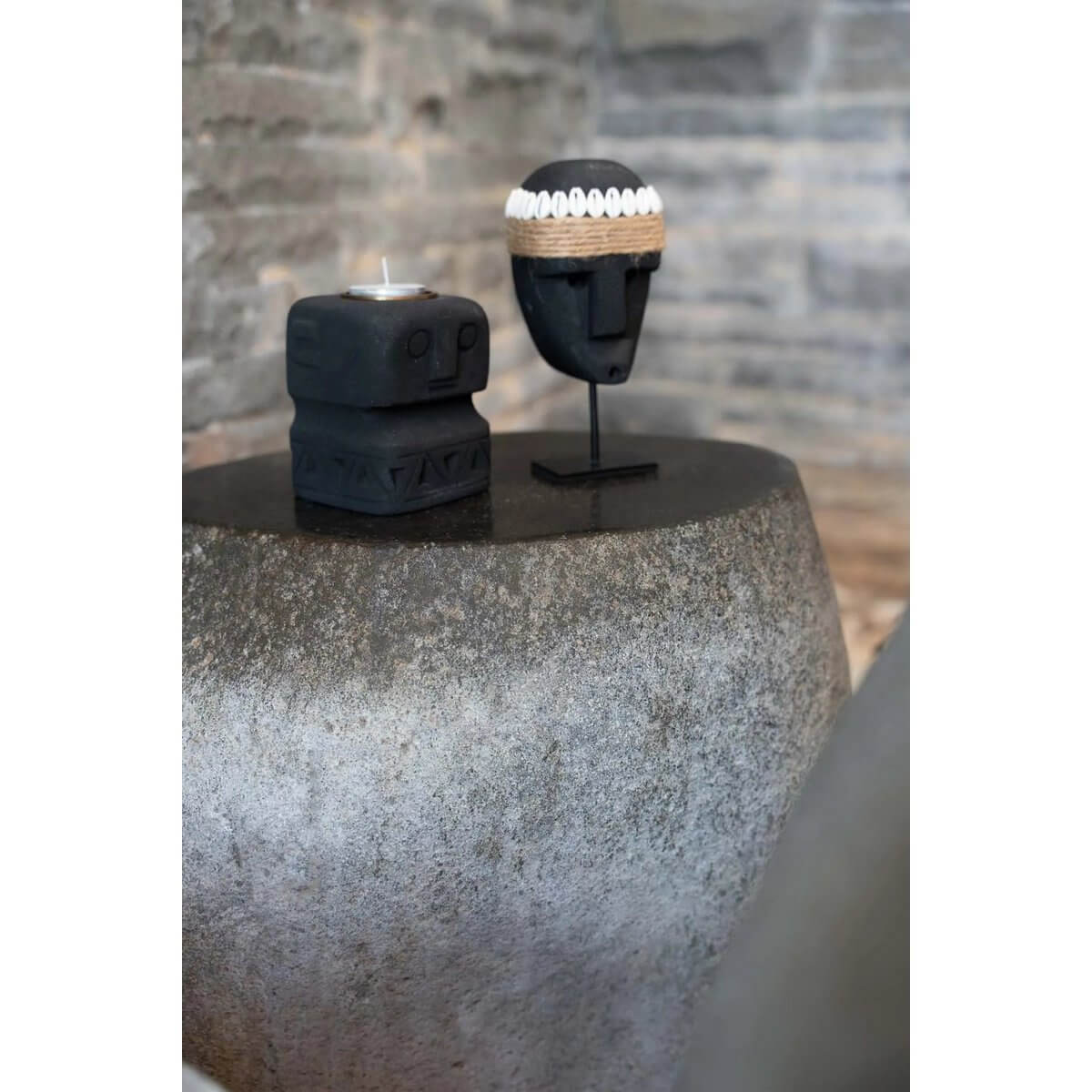 Bohemian Sumba stone candle holder from Indonesia on rustic table, handcrafted by local artisans for protection and healing.