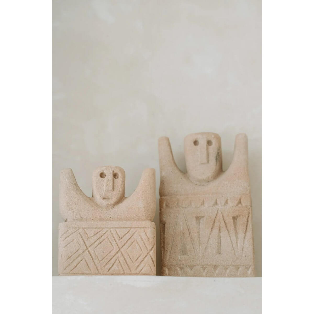 Two Sumba stone statues from Indonesia, hand-carved from sandstone, embodying bohemian charm and cultural artistry.