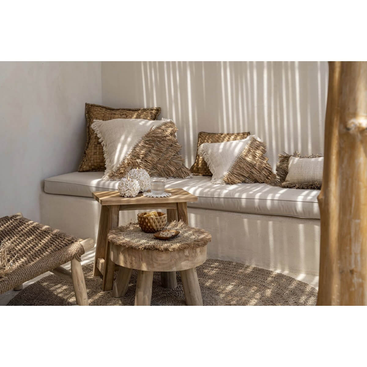 Cozy bohemian seating area with woven pillows, wooden tables, and a textured durian-inspired bowl for a stylish natural vibe.