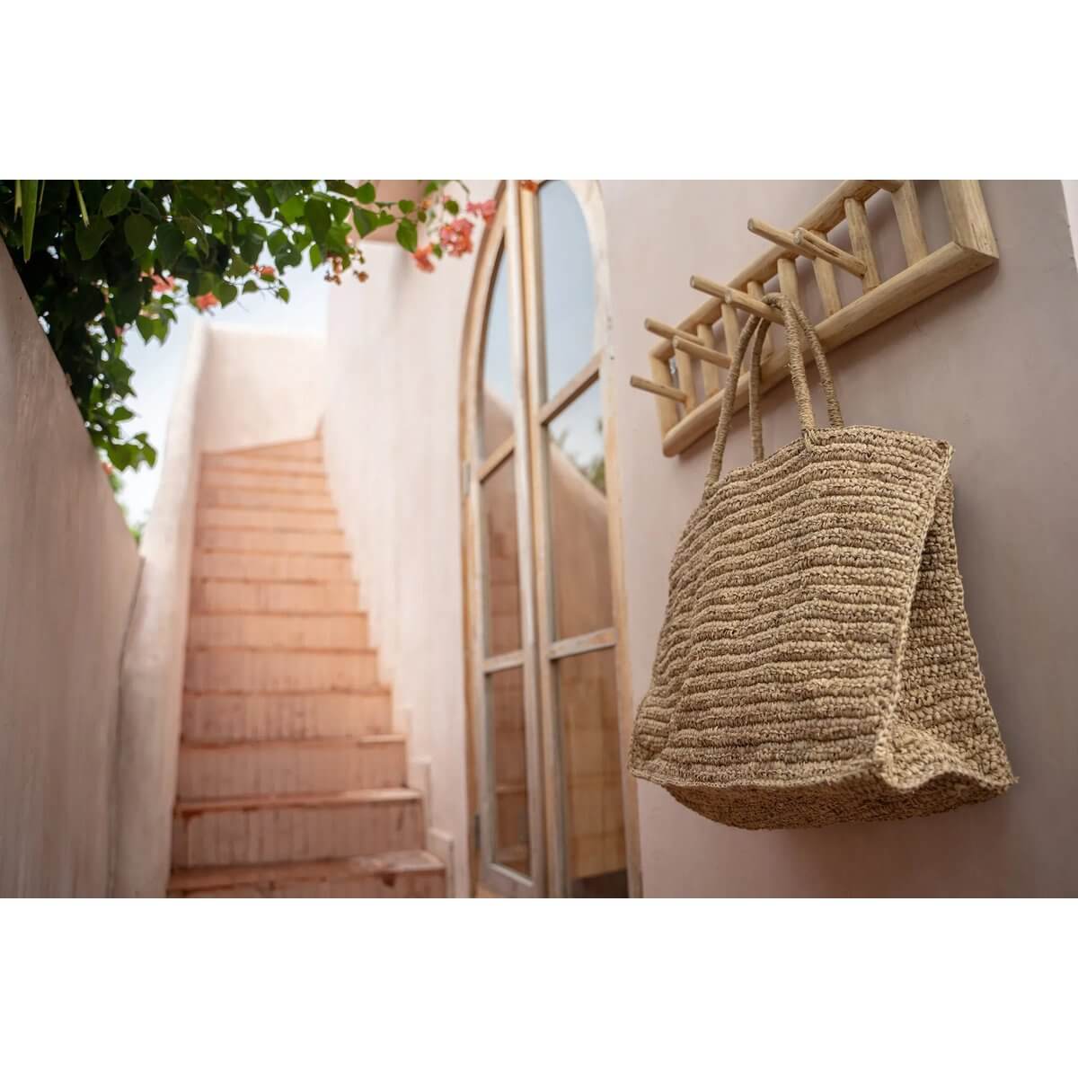 De Ti Amo raffia shopper tas hangt aan kapstok bij zonnige trap.