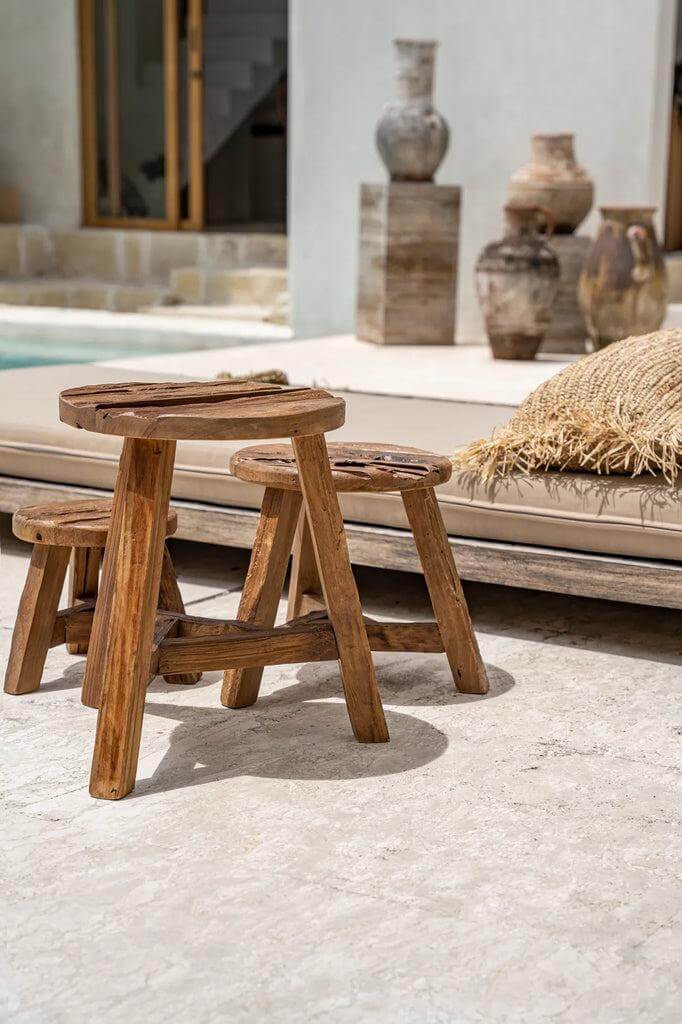 De Yatai krukken in drie maten van geüpcycled teakhout op een terras, natuurlijke rustieke uitstraling voor interieur.