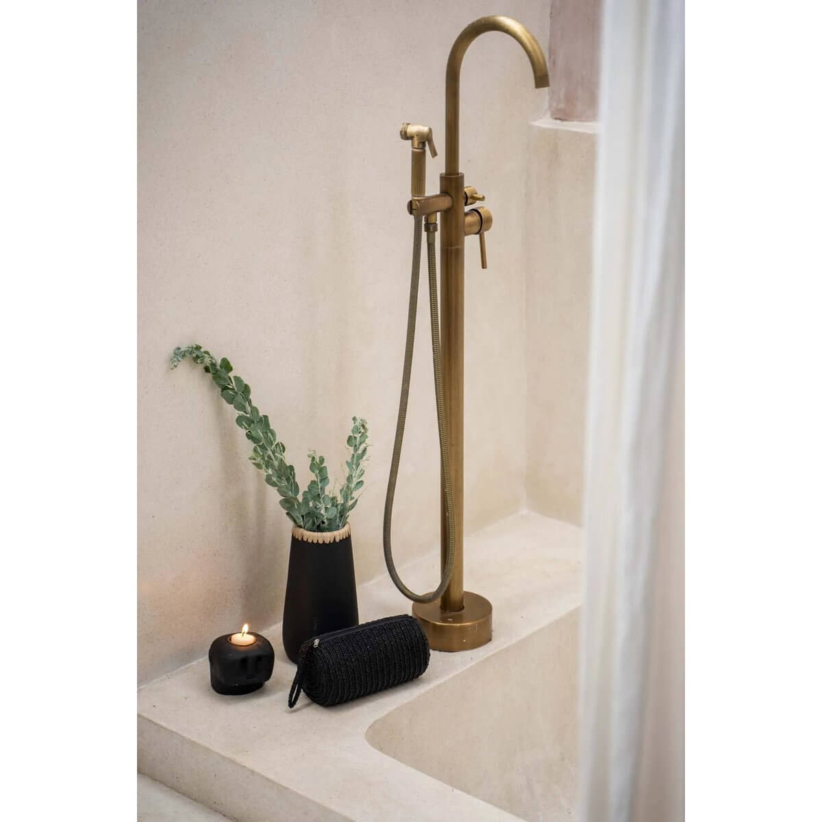 Stylish black pencil case next to a modern bathroom decor with brass faucet and candle, adding a chic touch to any Bohemian setting.