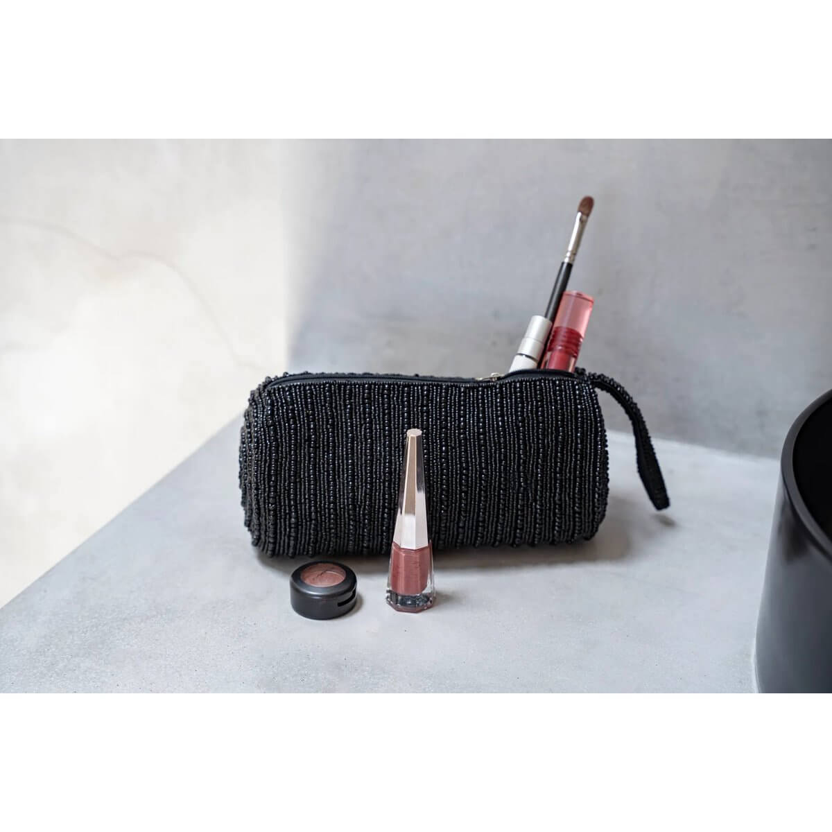 Stylish black pencil case with Bohemian flair, filled with makeup essentials like lipstick and brushes, perfect for organizing.