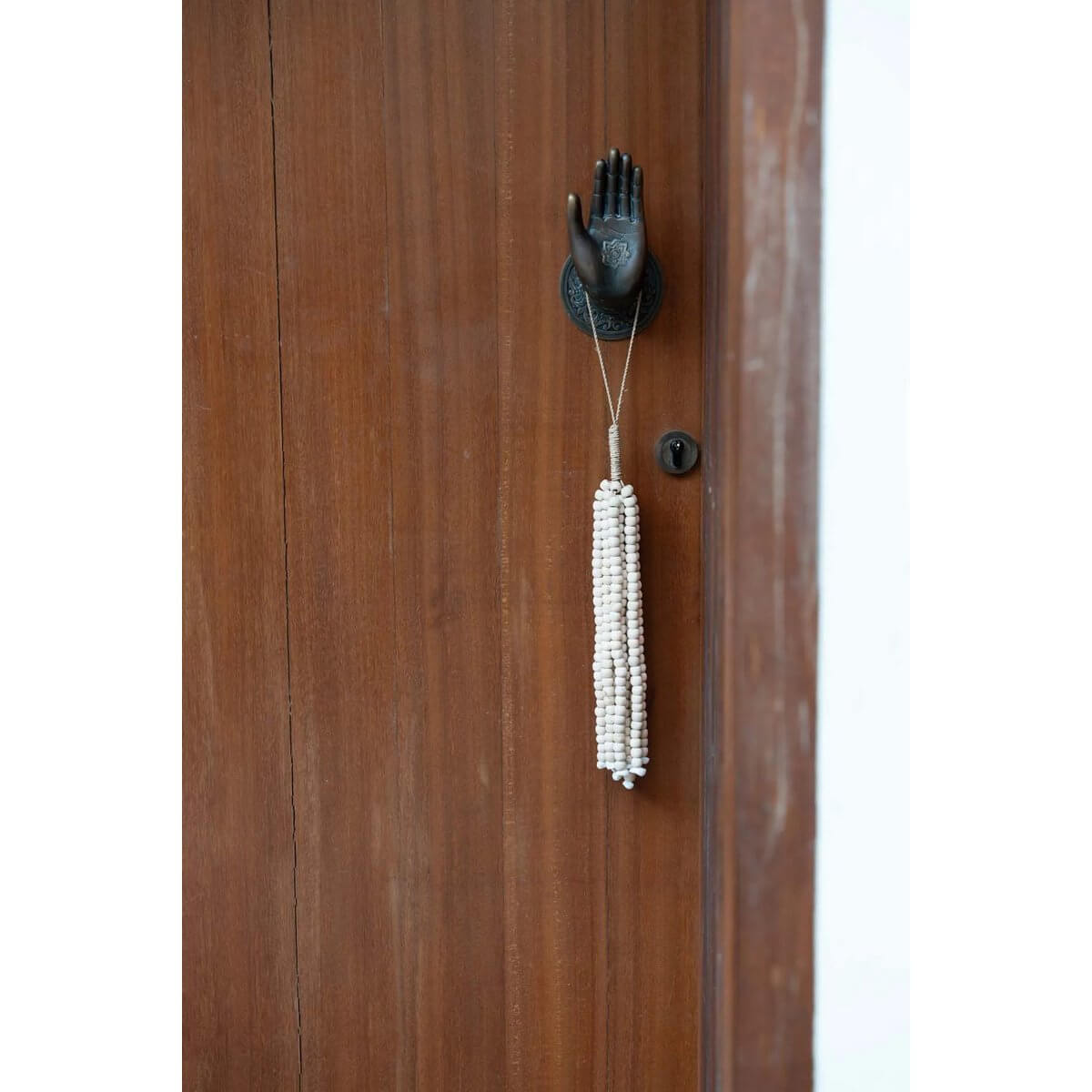 Bohemian style natural wooden bead tassel on door, handmade by Balinese artisans, exudes exotic charm for home decor.