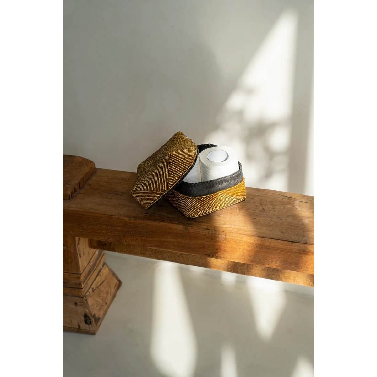 Handmade Balinese beaded box in gold, Bohemian style, on wooden bench; perfect for storage or decor.