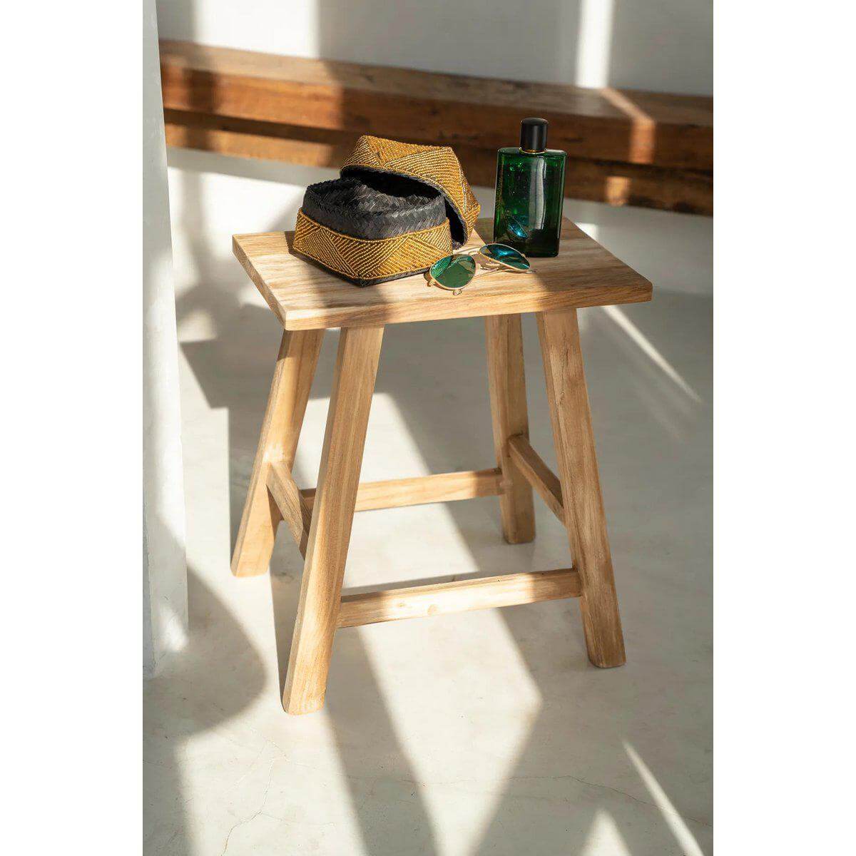 Handgemaakte Balinese kralenmand op houten kruk, perfect als decoratief element in je huis. Stijlvol en betekenisvol.