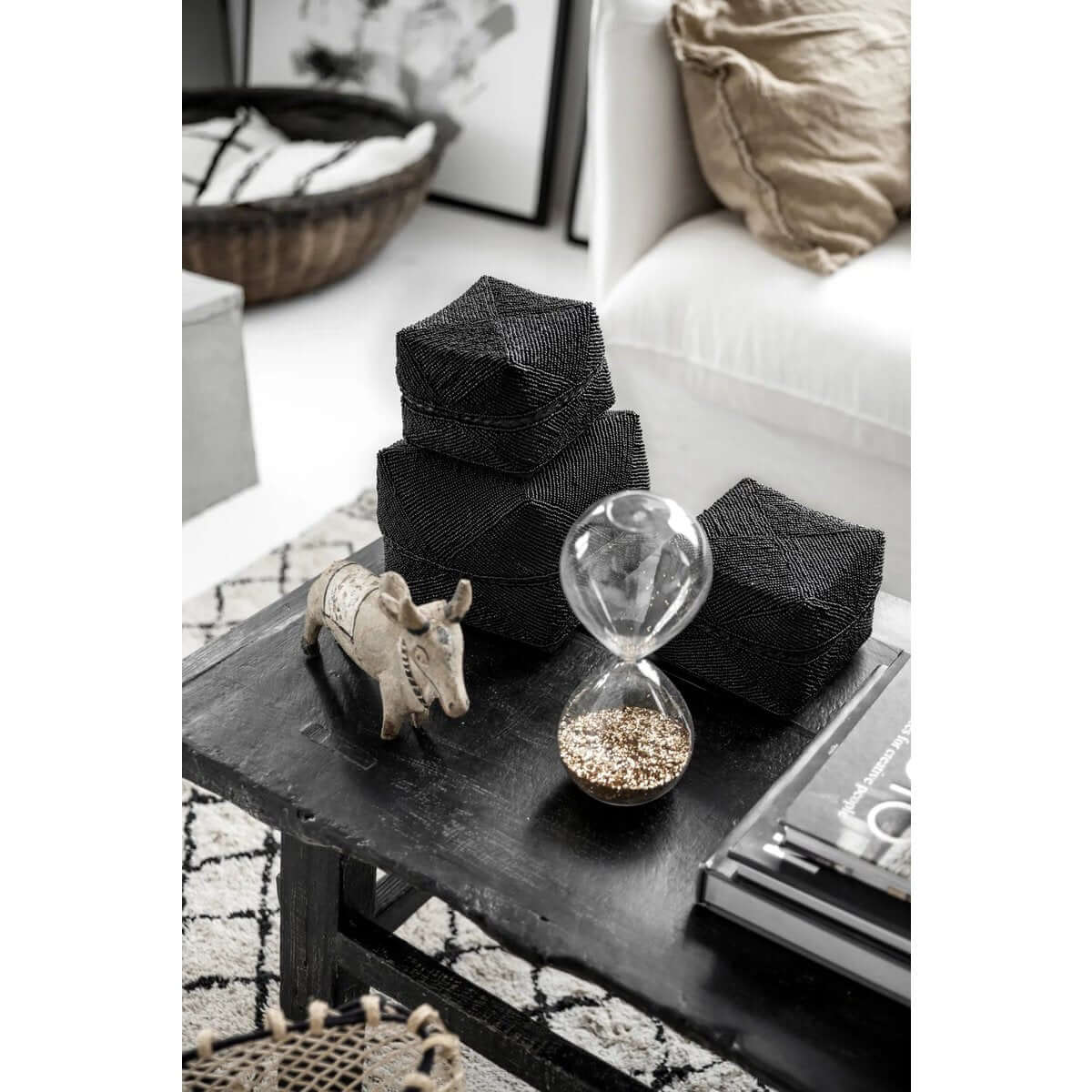 Bohemian style black beaded boxes handmade by Balinese artisans, displayed as decorative home decor on a modern coffee table.