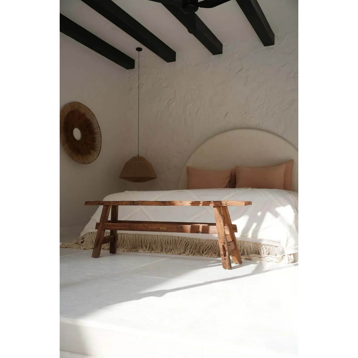 Rustic bohemian wooden bench in a serene bedroom with earthy tones and natural decor, adding warmth and elegance.