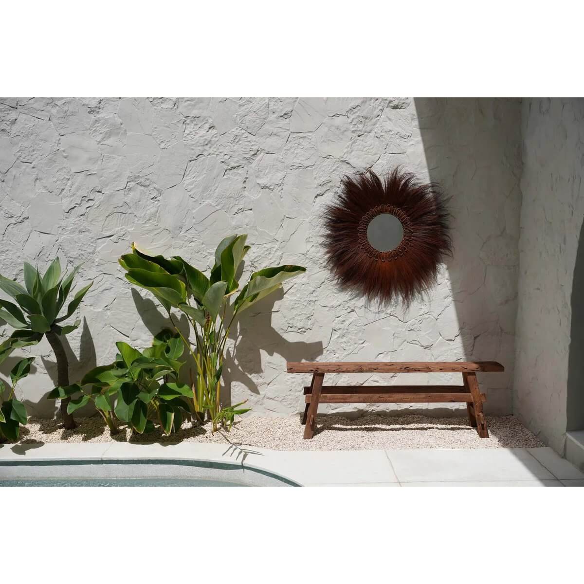 Bohemian charm with the Beauteous Rustic Bench outdoors, showcasing natural teak and earthy elegance near a sunlit wall and lush plants.