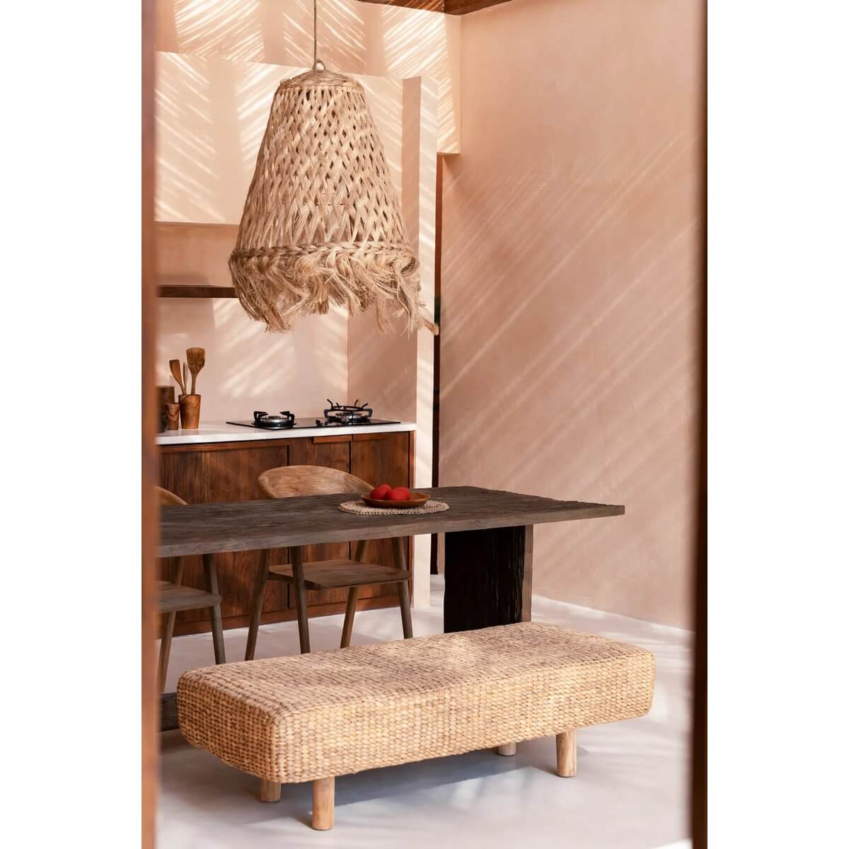 Bohemian Waterhyacinth Bench in cozy dining room setting, showcasing its sustainable, stylish design under a natural fiber light fixture.