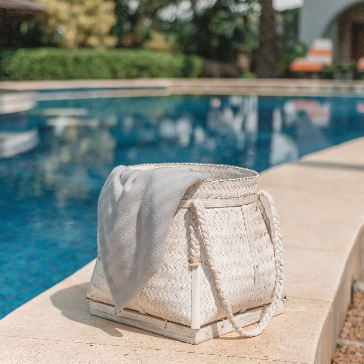 Bamboe Boho opbergmand Biku met handvatten bij het zwembad, duurzaam en 100% handgemaakt, ideaal voor decoratie of opslag.