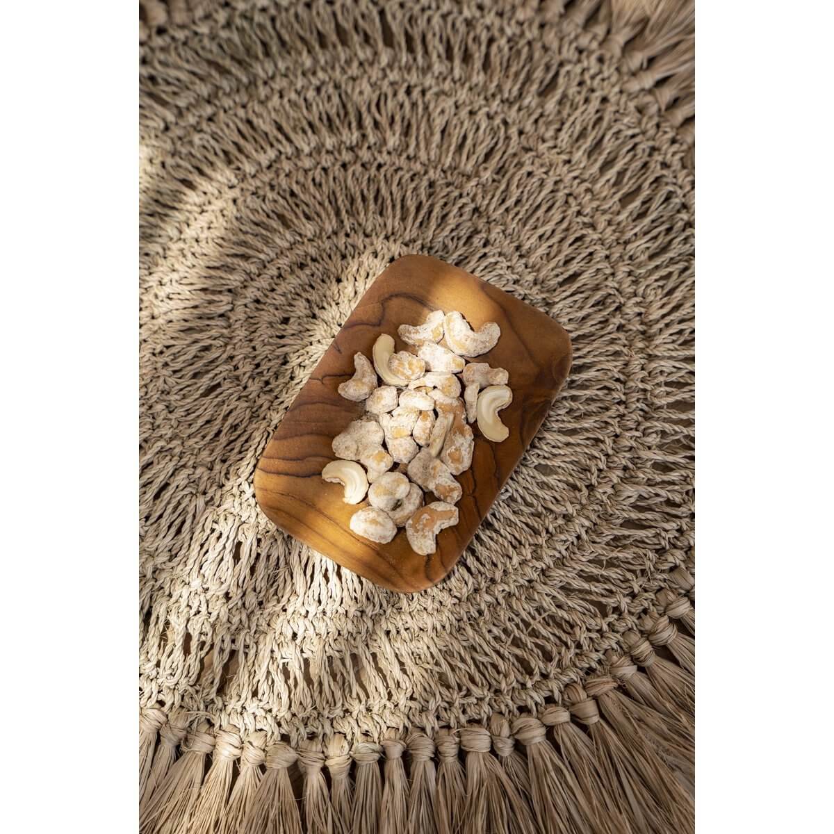 Het Teakwortel Bijgerecht Rechthoekig met cashewnoten op een Bohemian placemat, gemaakt van duurzame teakwortel.