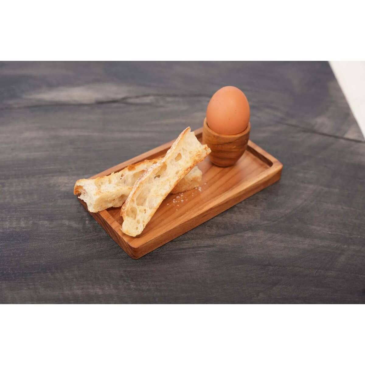 Bohemian teak root egg cup with toast soldiers on elegant wooden tray, perfect for stylish breakfast presentation.