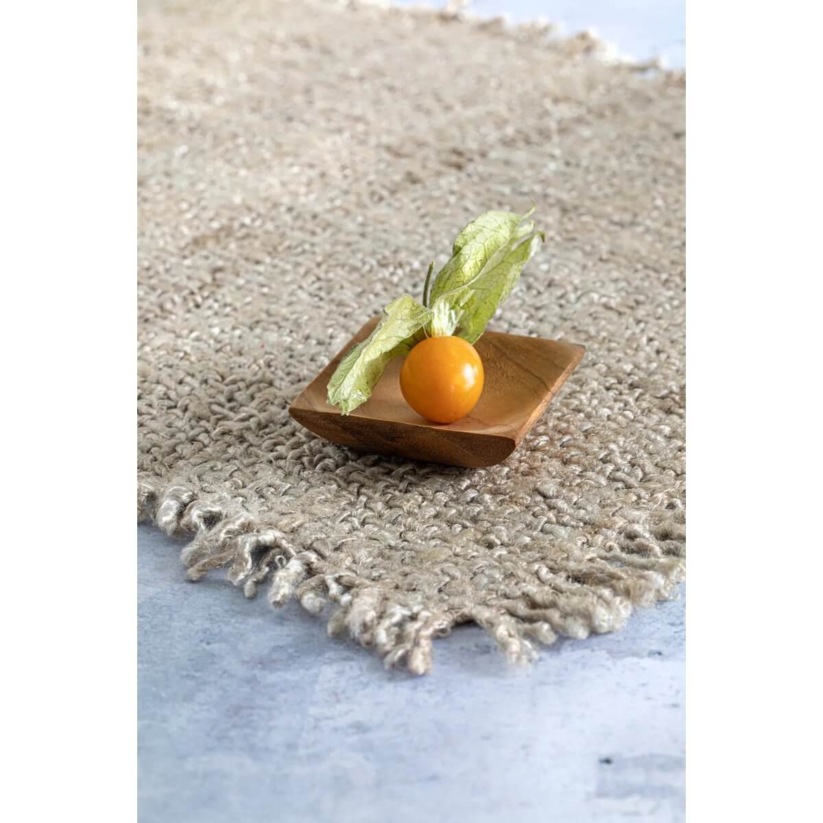 Bohemian style teak wood salt dish on woven rug, perfect for kitchen or jewelry use, featuring a physalis fruit for a natural touch.
