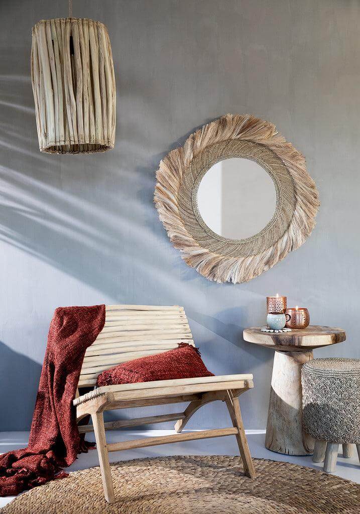Boho chic woonkamer met waterhyacint tapijt, houten stoel en rustieke decoratie in natuurlijke tinten.
