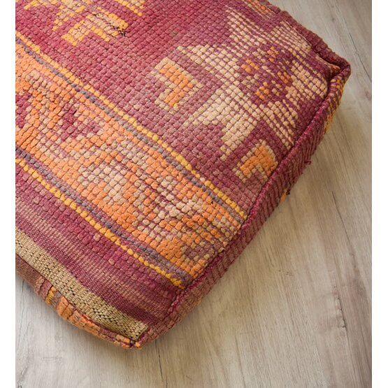 Vintage Marokkaans vloerkussen met bohemian patroon, handgemaakt van een berberkleed, op houten vloer.