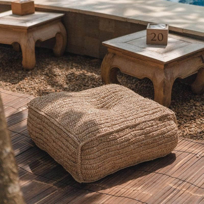 alt_tag: Handgeknopte raffia poef Padar op houten terras. Comfortabel zitelement, duurzaam en plasticvrij. Perfect voor elke tuin.