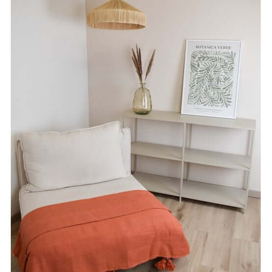 Stijlvol interieur met Marokkaanse pompomdeken in oranje op een bankje, ideaal als knus statement piece. Geschikt voor elke woonstijl.