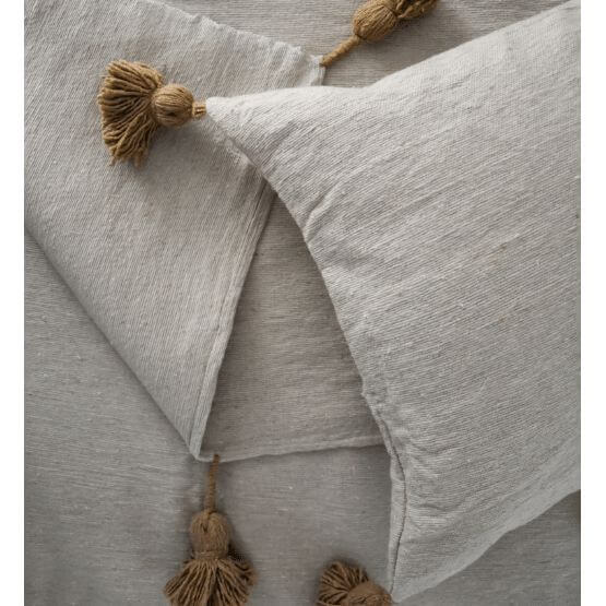 Marokkaanse pompomdeken in crèmekleur met beige details en pompons, perfect voor een warme en stijlvolle toevoeging aan je interieur.