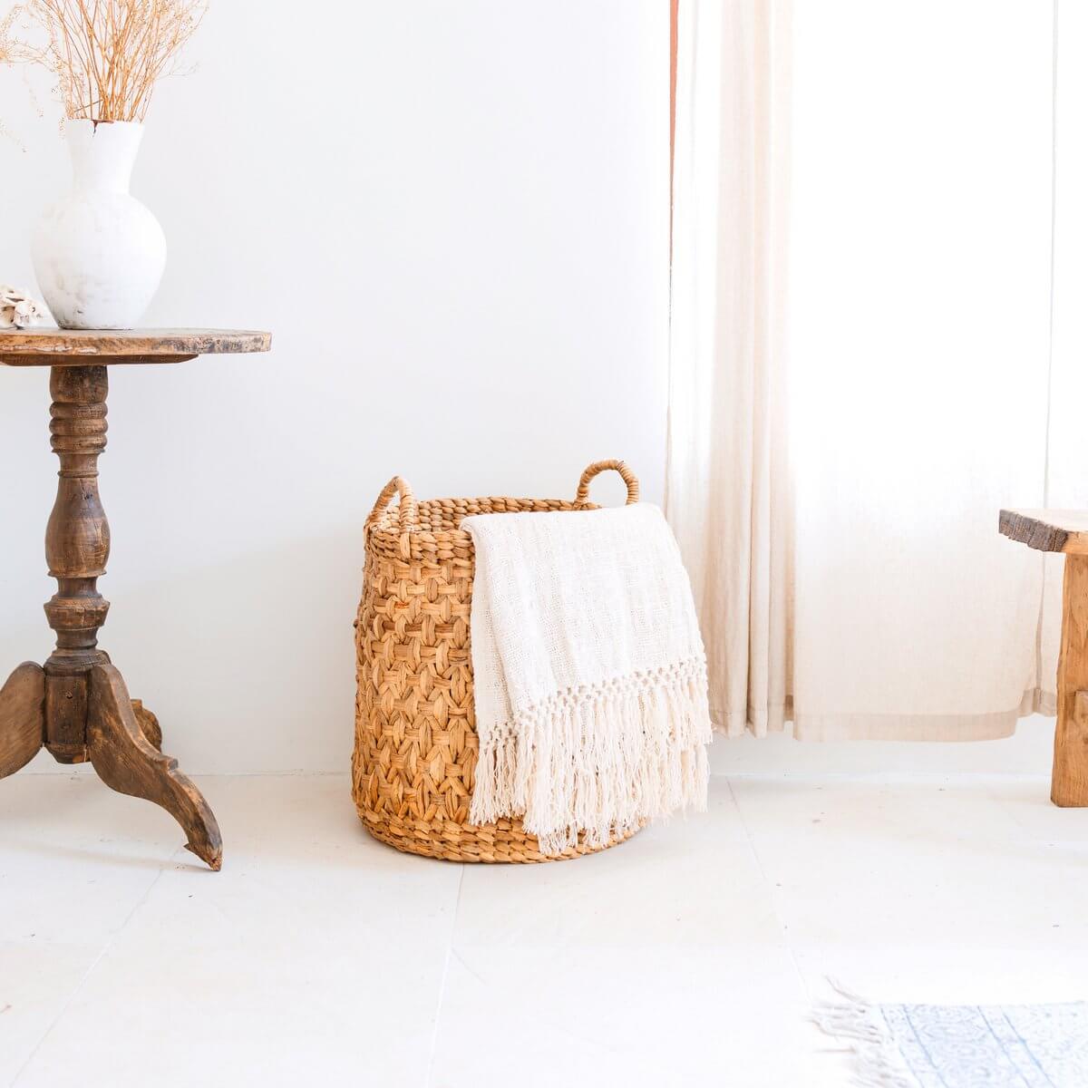 Stijlvolle handgemaakte wasmand van waterhyacint met een deken, boho design, geschikt voor woonkamer of badkamer interieur.