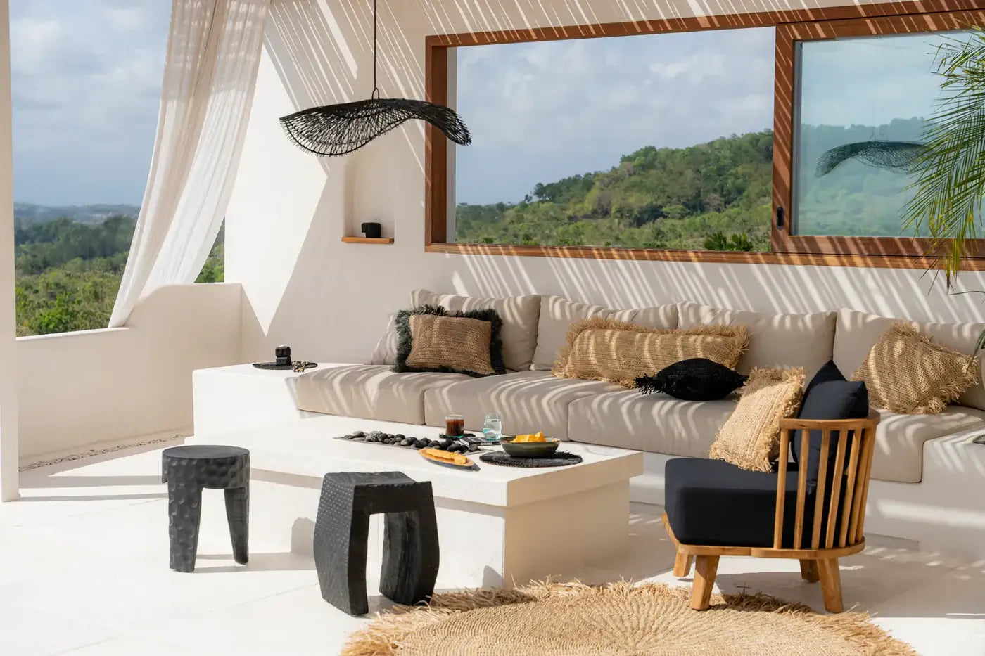 Stylish living room featuring Rotan Hanglamp Chapeau Zwart, creating a bohemian luxe atmosphere with natural light and modern decor.