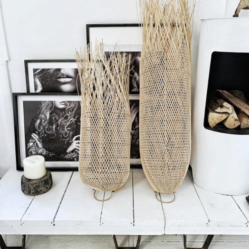 Decoratieve rotan lampen omgeven door kunst en interieuraccessoires, op een witte tafel tegen een stijlvolle achtergrond.