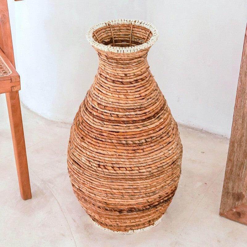 Alt Tag: Handgemaakte vaas van natuurlijk riet, gemaakt met traditionele vlechttechnieken. Stijlvol ontwerp met lichtgekleurde raffia.