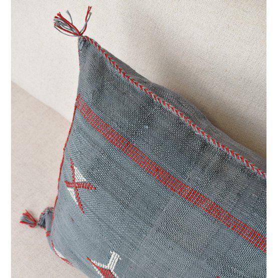 Donkergrijs Sabra kussen met rode accenten en bohemian uitstraling, ideaal voor een sfeervolle tuinset.