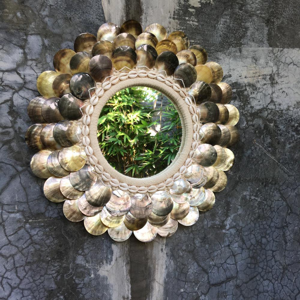 The Coin Spiegel - Naturel Bruin - M Bazar Bizar Deze prachtige Cotton Shell wandspiegel met schelp details voegt een 'coastal' touch toe aan elke kamer, met een vleugje boho chic styling. Hoogte (cm) 40 Lengte (cm) 40 Kleur Naturel Bruin Materialen Shell