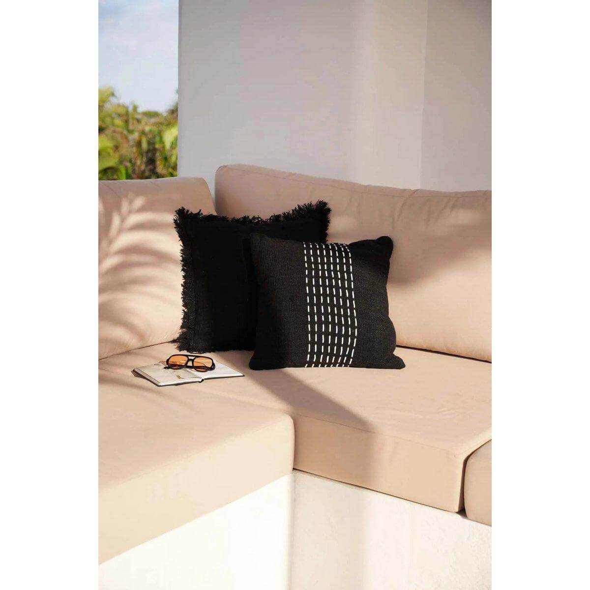 Zwart-witte Drizle kussenhoes op beige bank, elegante aanvulling voor moderne interieurstijlen.