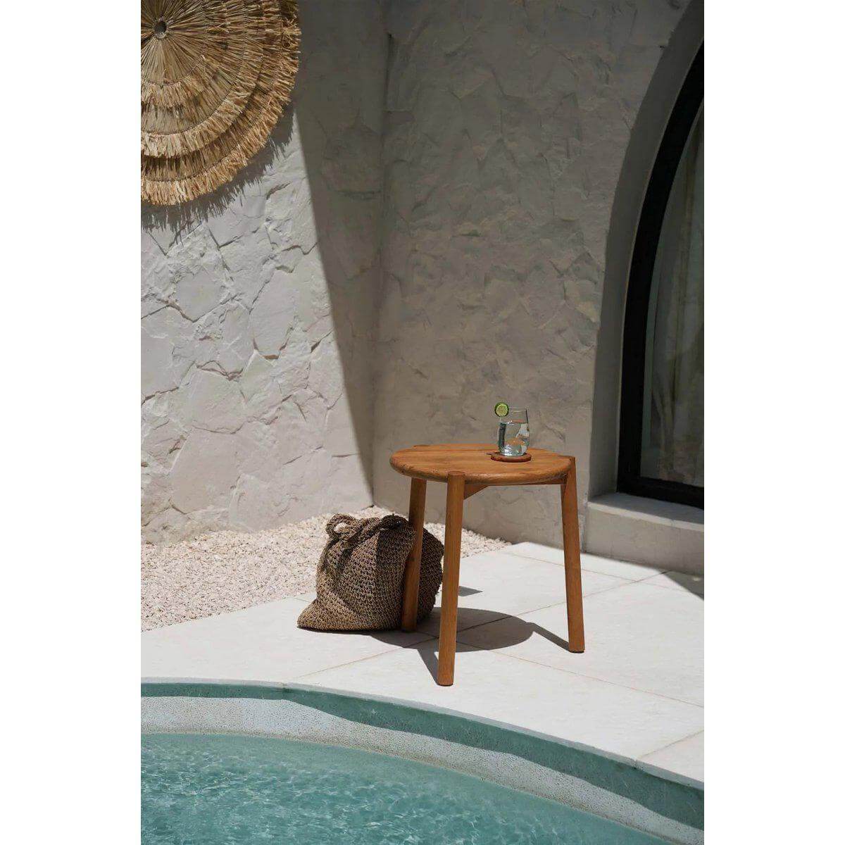 Island Tote rugtas naast houten tafel bij zwembad met drankje, perfect voor stranddagen of stadsavonturen in stijl.