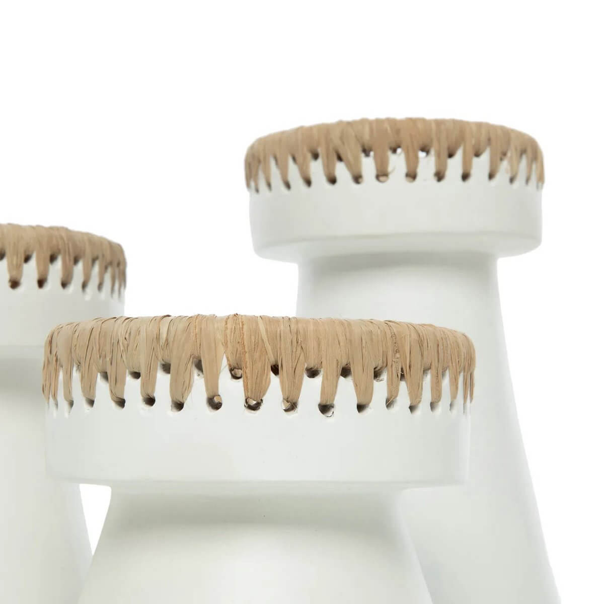 Bohemian white terracotta candle holders with raffia accents showcasing stylish home decor elegance.