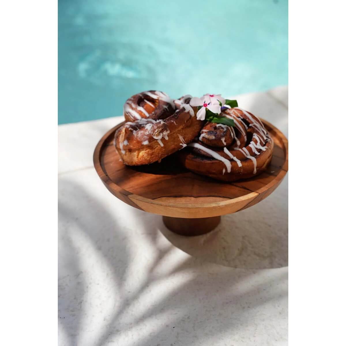 Bohemian Teak Root Cake Dish displaying pastries by the pool, perfect for chocolate, candy, or desserts. Width: 24.5cm, Height: 13cm.