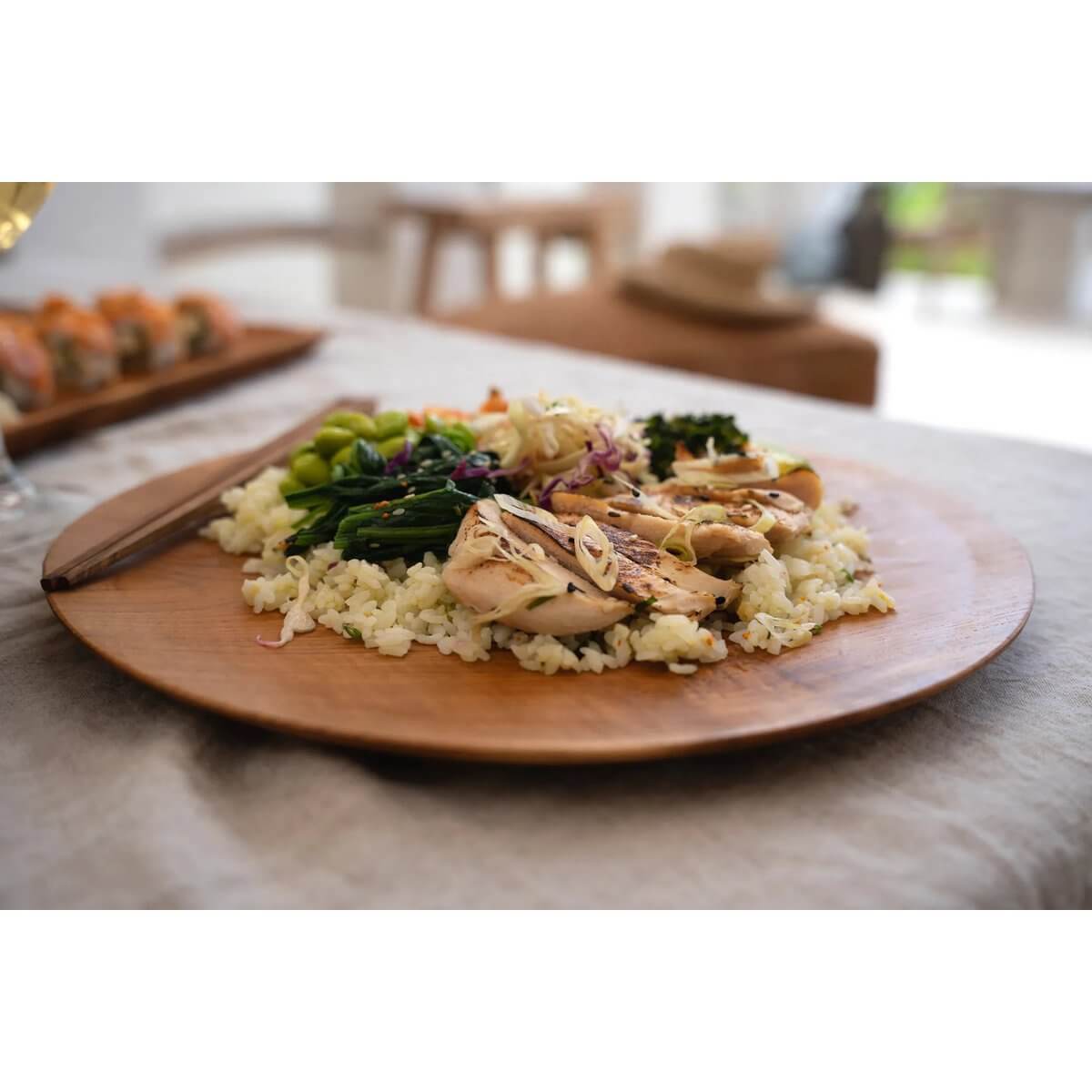 Alt Tag: Bohemian-style meal served on a Teak Root Round Plate, adding a warm wooden touch, perfect for diverse table settings.