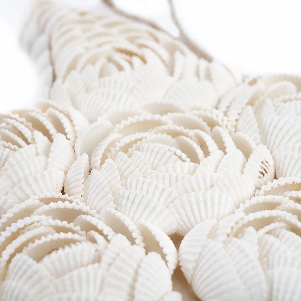 De Ster Shell - Wit - L Bazar Bizar Deze decoratieve zeester is helemaal gemaakt van mooie witte schelpen, aan elkaar geplakt in de mooie vormen van bloemen. Je kunt hem in je badkamer ophangen aan zijn koord, of op een plank of (bijzet)tafel zetten om ov
