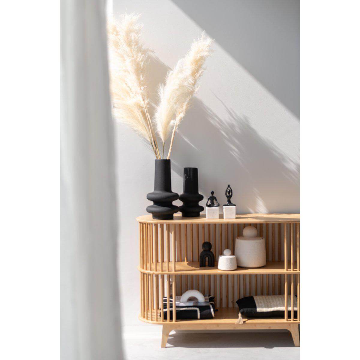 Houten kast met decoratieve J-Line Vaas Lyra Klei Zwart Large en pampas, creëren een stijlvolle en elegante interieurlook.